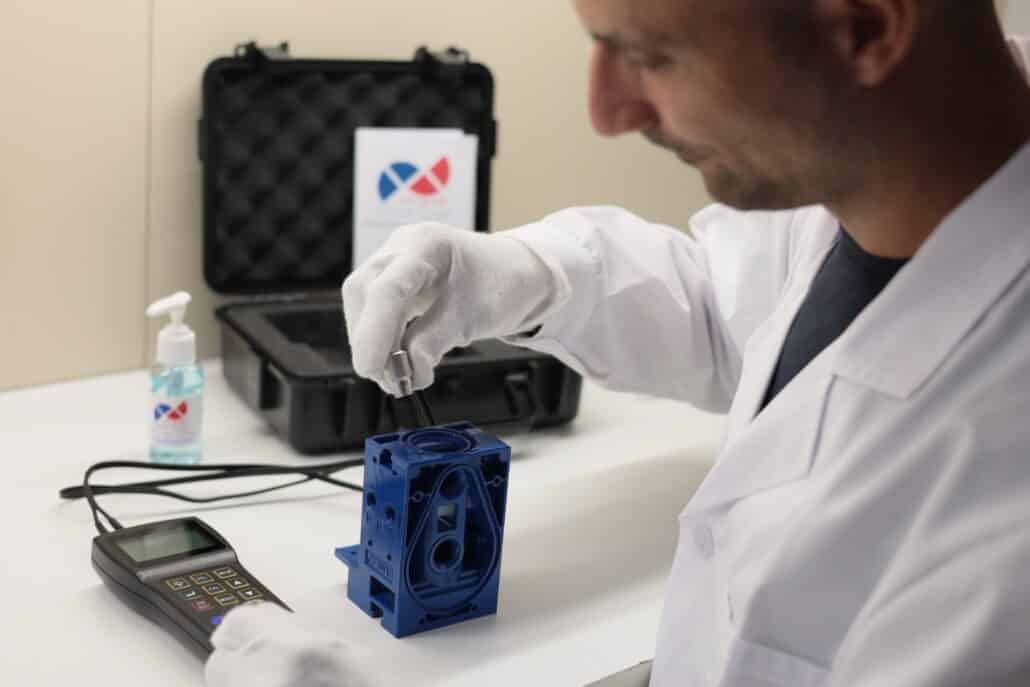Measuring Metal Thickness Through Paint: The Progetto PSC Case Study 2 technician measuring a painted component with through coating thickness gauge